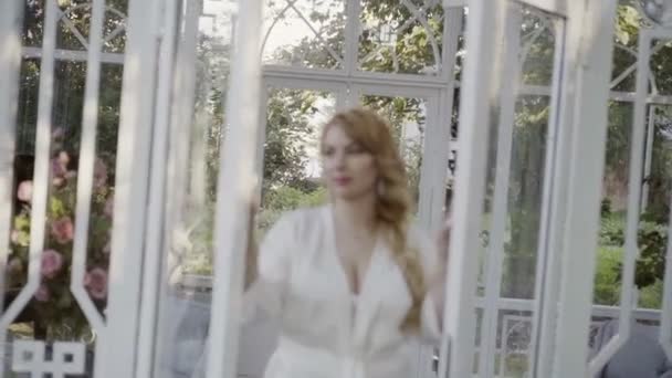 Cute young blonde woman in lingerie open glass doors defocus — Stock Video