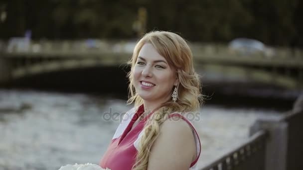 Söt ung blond kvinna i röd klänning vistas på vallen — Stockvideo