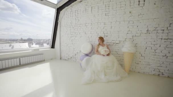 Sød ung blondine kvinde i brudekjole poserende i studiet med enorm is – Stock-video