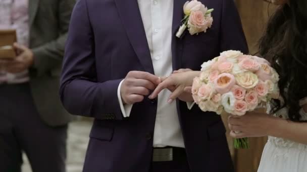 Ceremonia de boda: el novio pone un anillo en la mano de la novia — Vídeos de Stock