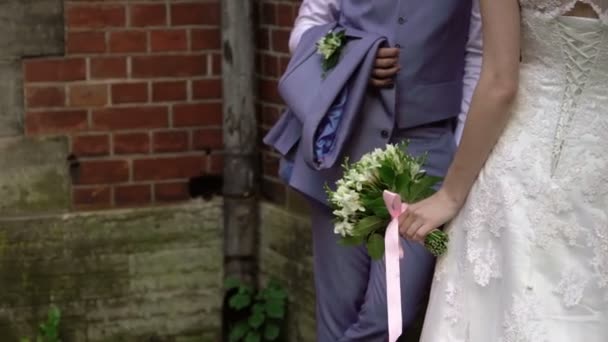 Esküvői pár ház fala közelében tartózkodó — Stock videók