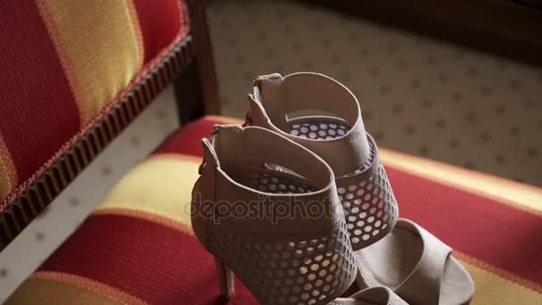 Женская обувь на стуле — стоковое видео