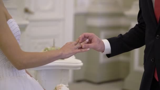 Весільна церемонія: наречений кладе перстень на руку нареченій — стокове відео
