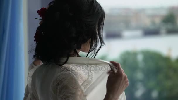 Woman in lingerie undressing near window — Stock Video