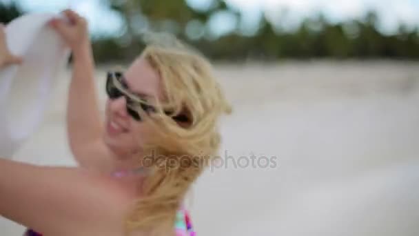 Mujer joven en bikini dando vueltas en la playa — Vídeo de stock