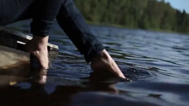 Young woman sitting near lake — Stock Video