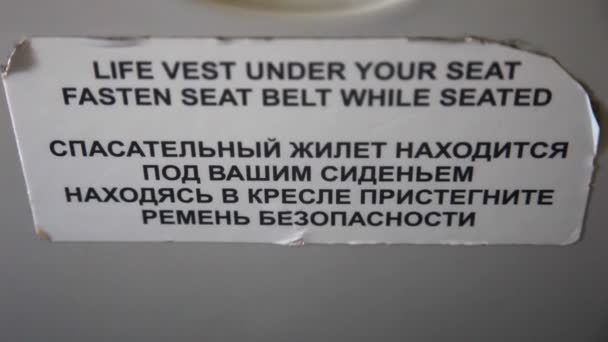 Life vest under your seat fasten seat belt sign in airplane — Stock Video