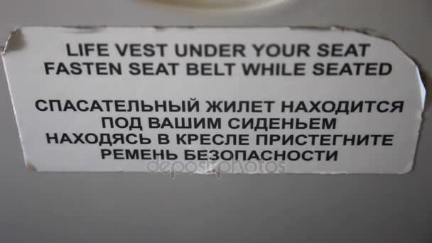 Life vest under your seat fasten seat belt sign in airplane — Stock Video