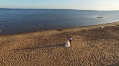 Evlilik çift Sahilde yürüyüş. 4k hava vurdu