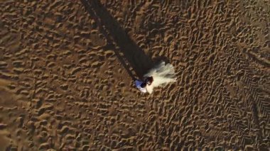 Evlilik çift Sahilde yürüyüş. 4k hava vurdu