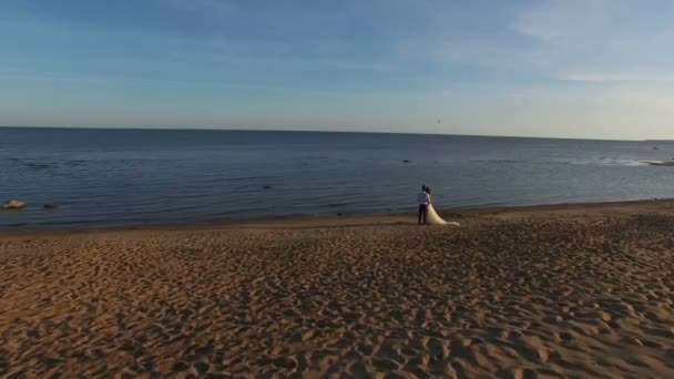 Paar staande op een strand bruiloft. 4k luchtfoto schot — Stockvideo