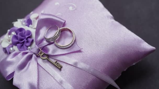 Wedding rings on purple pillow — Stock Video