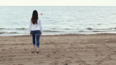 Kumsalda yürüyen genç bir kadın