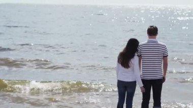 Bir kumsalda kucaklayan genç güzel Çift