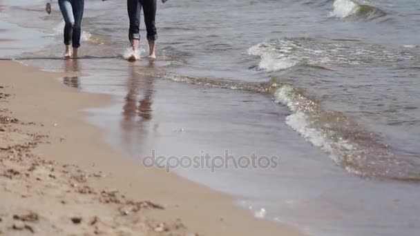 Jonge mooie paar wandelen op een strand — Stockvideo