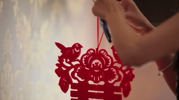 Jonge vrouw versieren kamer met Chinees symbool — Stockvideo