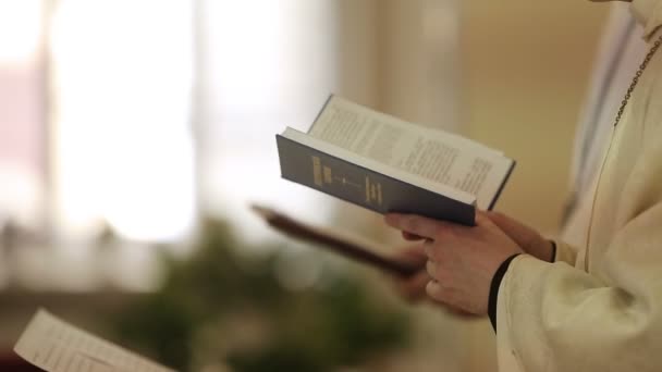 Sacerdote en la iglesia con la Biblia — Vídeos de Stock