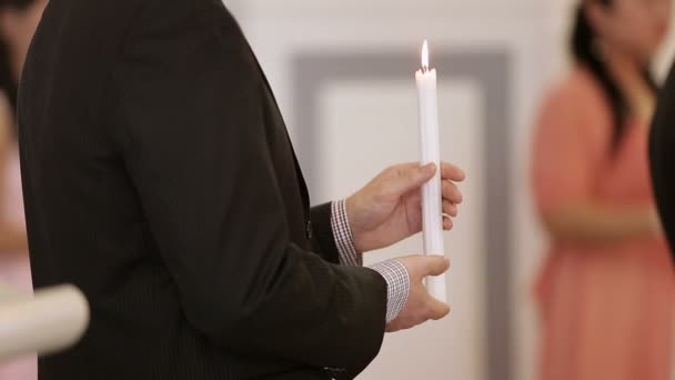 Mann im schwarzen Anzug in Kirche mit Kerze — Stockvideo