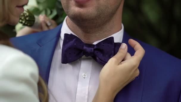 Młoda kobieta dotyka mans bowtie — Wideo stockowe