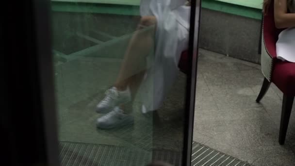 Düğün elbise ve spor ayakkabı sandalye üzerinde oturan kadın — Stok video