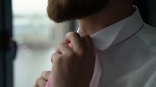 Mann trägt Krawatte am Fenster — Stockvideo