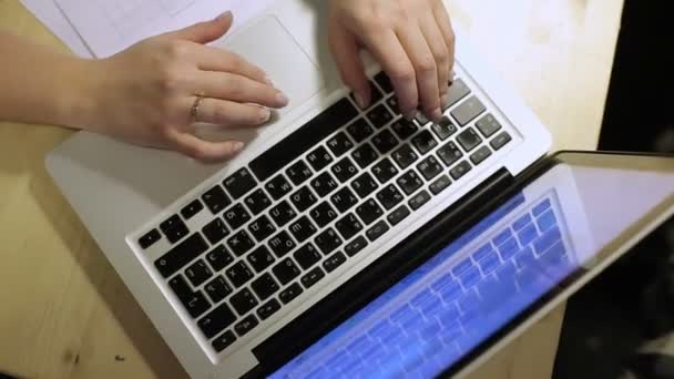Mujer joven en la oficina trabaja con el ordenador portátil — Vídeo de stock
