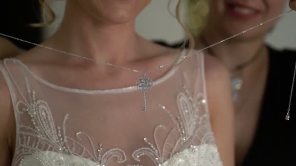 Dama de honor lleva un colgante al cuello de la novia — Vídeo de stock