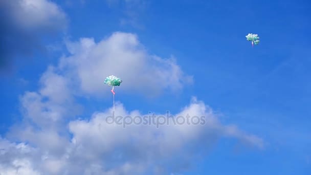 Много воздушных шаров летит в голубом небе — стоковое видео