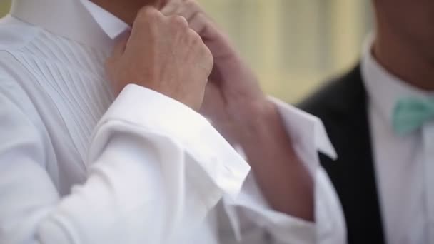 Brudgummen bär knäppning vit skjorta — Stockvideo