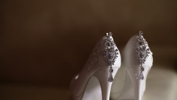 Gyönyörű fülbevaló és fehér női cipő — Stock videók