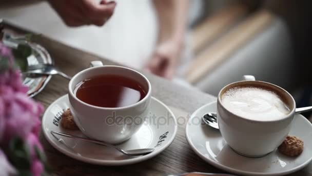 Man en vrouw drinken thee en koffie — Stockvideo