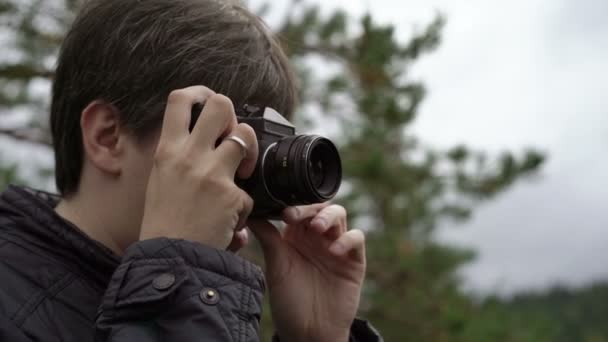 Jeune homme avec caméra de film prenant des photos — Video