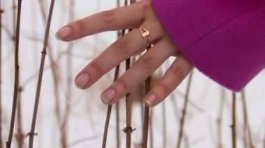 Kış ormanda yürüyüş ve dalları dokunmadan pembe ceket genç kadın