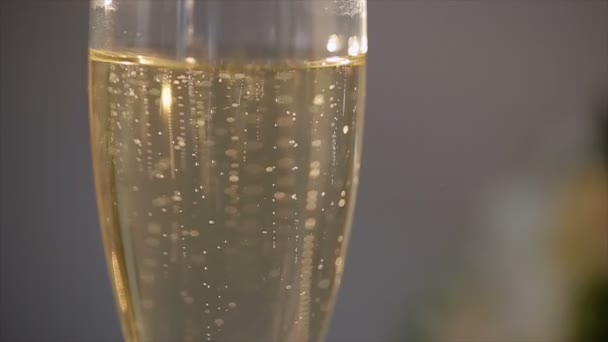 Wedding rings falls to glass of champagne — Stock Video
