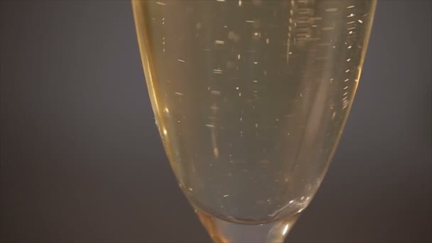 Обручальные кольца падают на бокал шампанского — стоковое видео
