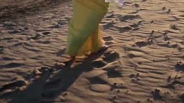 Sahilde yürüyüş sarı elbiseli kadın