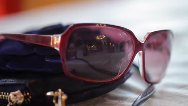 Frauensonnenbrille auf dem Tisch — Stockvideo