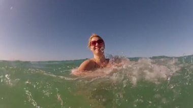 Sarışın genç kadın bir denizde iyi eğlenceler