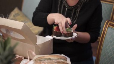 Genç kadın pasta tabak içinde alır.