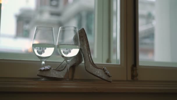 Zenske bílé boty a dvě sklenice šampaňského — Stock video
