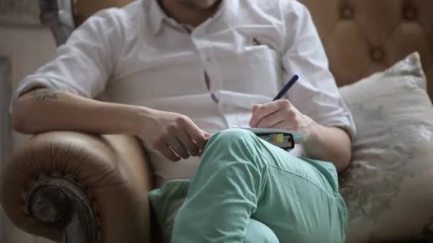 Hombre escribiendo en cuaderno sobre conferencia — Vídeos de Stock