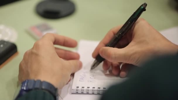 Hombre escribiendo en cuaderno sobre conferencia — Vídeo de stock