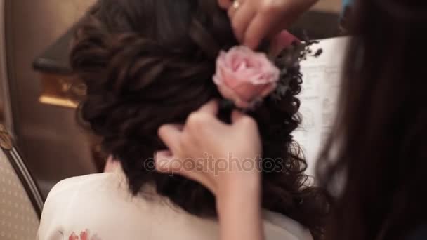 El peinado de las novias - la flor rosada en el cabello — Vídeo de stock