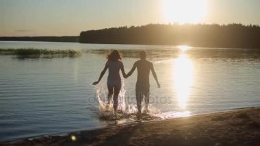 Bir kumsalda kucaklayan genç güzel Çift