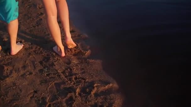 해변에서 맨발로 걷는 젊은 아름 다운 부부 — 비디오