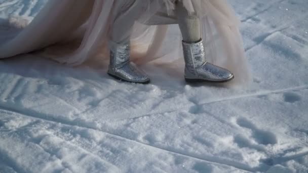 Vrouw in lange jurk en zilveren schoenen lopen bij winterdag — Stockvideo