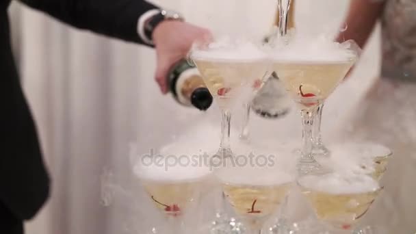 Novia y novio vertiendo champán a la pirámide de vasos — Vídeo de stock