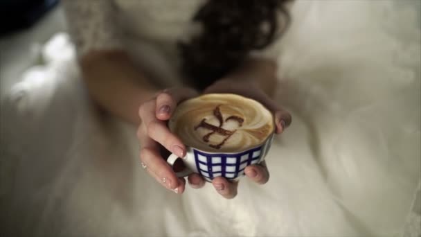 Νεαρή γυναίκα στο νυφικό με φλιτζάνι καφέ — Αρχείο Βίντεο
