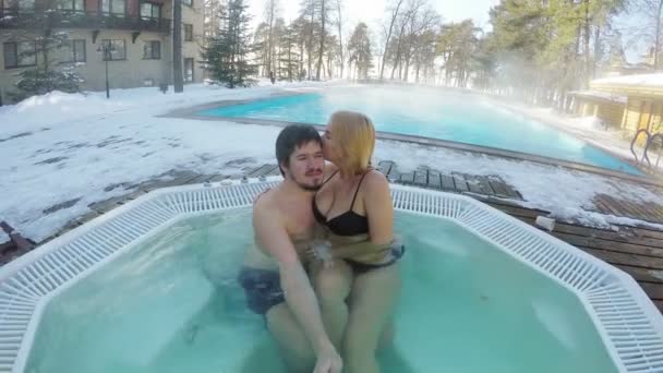 Pareja joven en bañera de hidromasaje jacuzzi al aire libre en autofoto de invierno — Vídeos de Stock