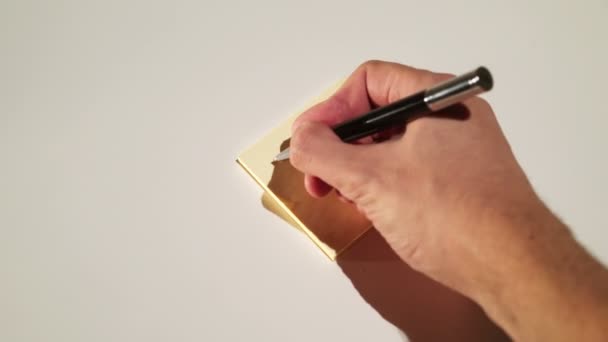Person, der skriver på stick note telefonnummer – Stock-video